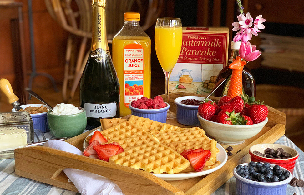 breakfast tray with waffles, fresh fruit, Trader Joe's Blanc de Blancs Sparkling Wine and orange juice with a mimosa