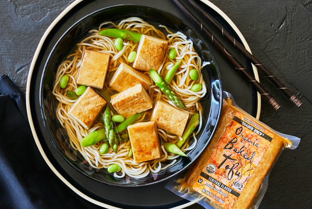 Trader Joe's Organic Baked Tofu Teriyaki Flavor pices included in a bowl of noodle soup with asparagus and edamame