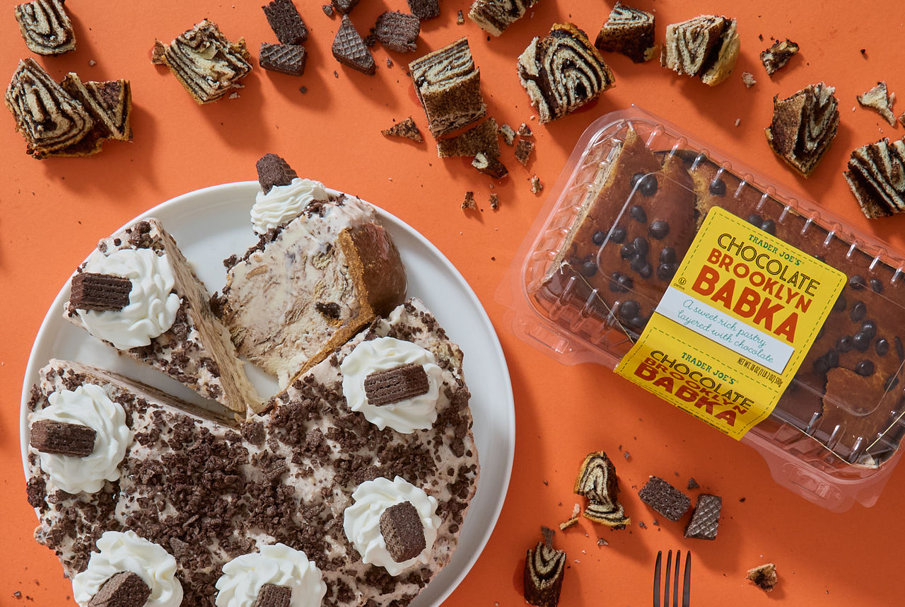 Trader Joe's Chocolate Brooklyn Babka; shown in recipe for Brooklyn Babka Ice Cream Cake; orange surface with ice cream cake on plate; with a couple slices, one on its side; pieces of babka and chocolate wafer cookies around surface