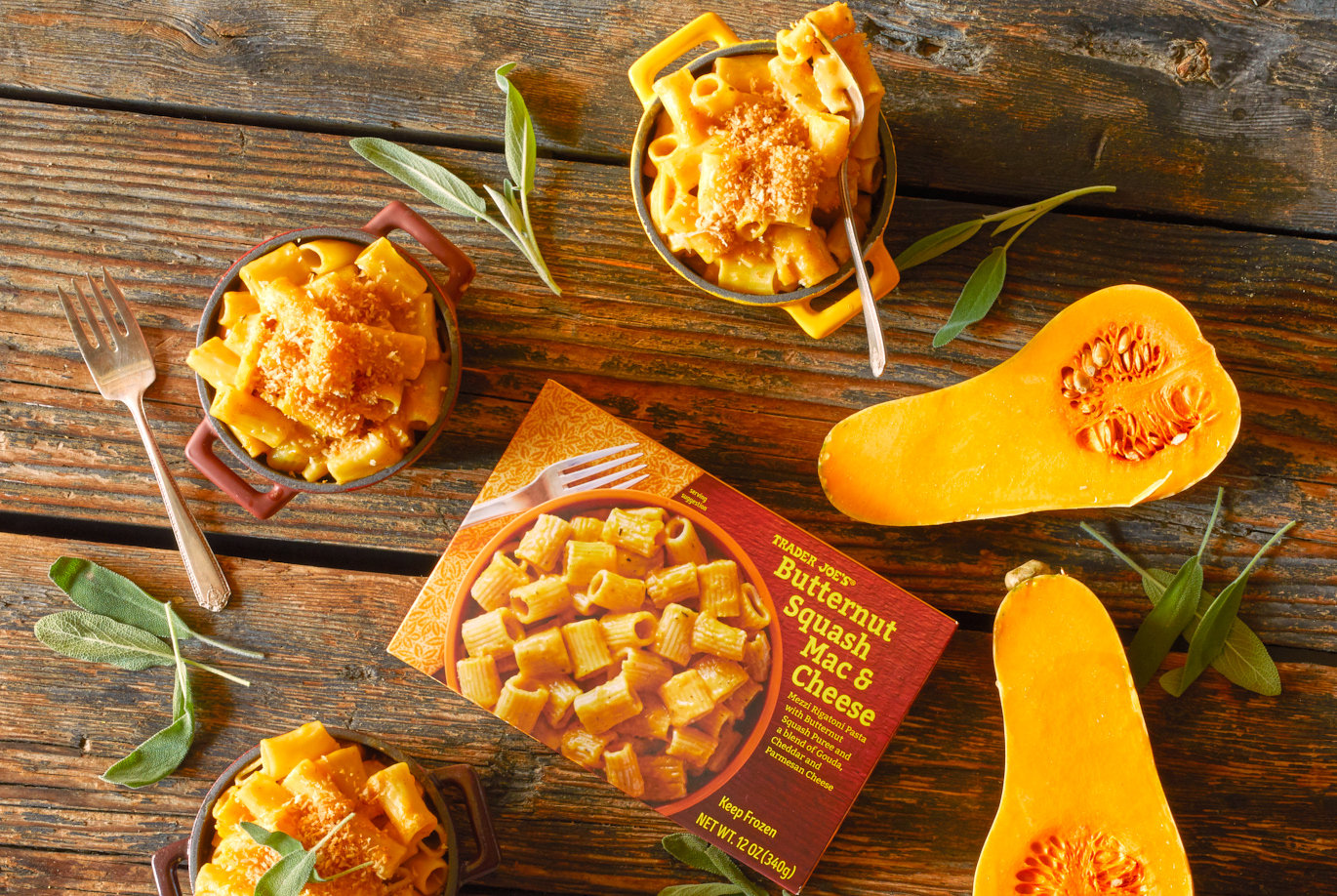 Trader Joe's Butternut Squash Mac & Cheese; served in 3 small skillet pots with handles; on rustic wood surface, with butternut squash halves on right