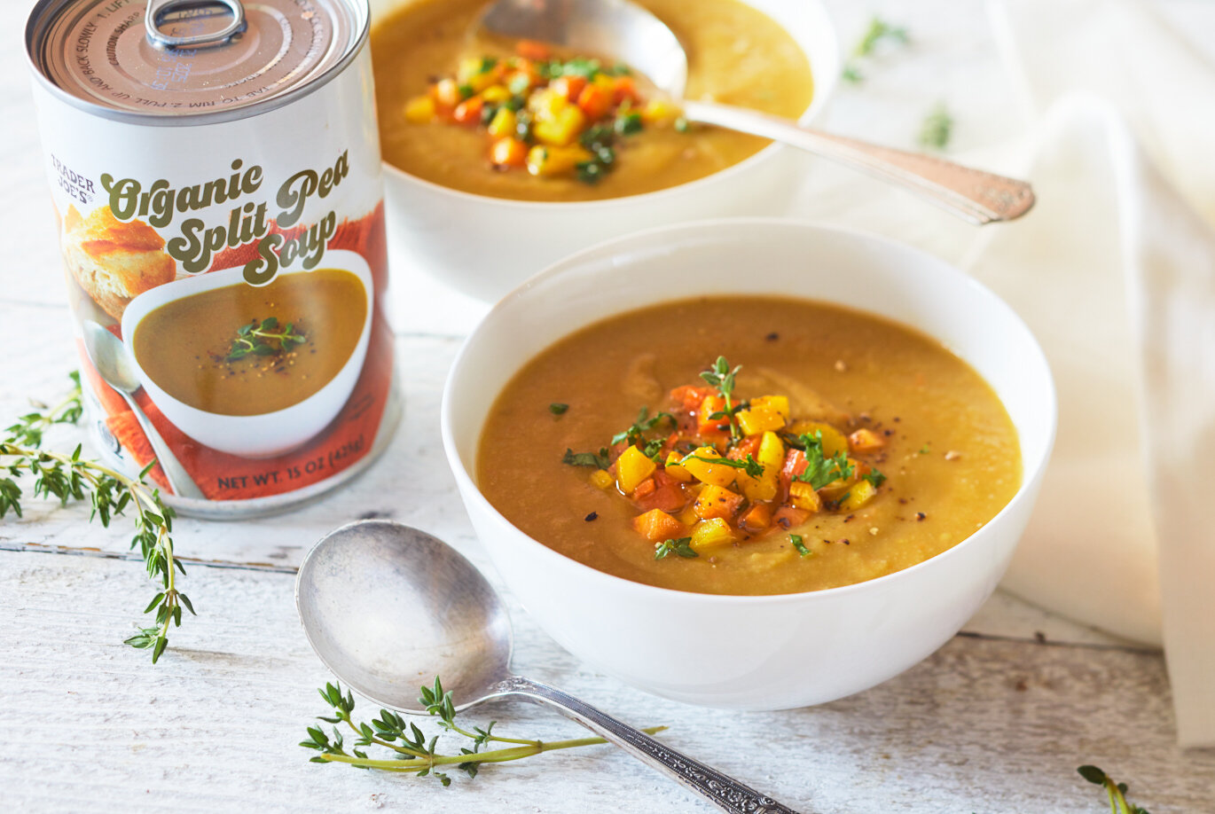 Trader Joe's Organic Split Pea Soup served in two white bowls, with fresh thyme garnish