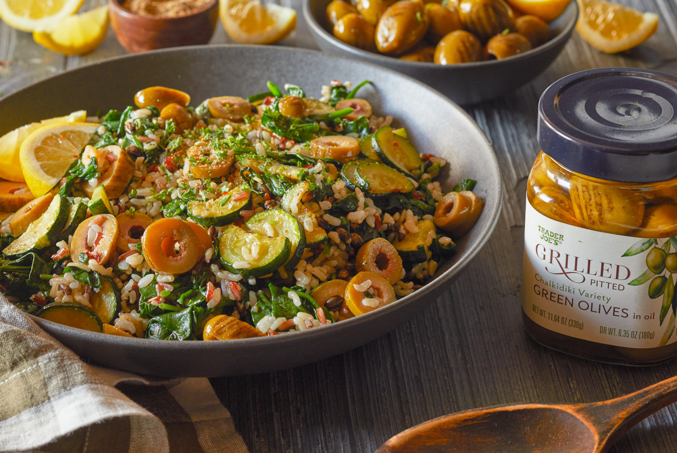 Trader Joe's Grilled Green Pitted Olives; shown in recipe for rice medley salad, with spinach and zucchini; lemon wedges and spices garnish