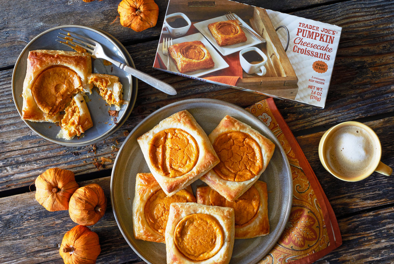 Trader Joe's Pumpkin Cheesecake Croissants; arranged on a serving platter, one on a plate with fork marks and pieces, cup of coffee next to it