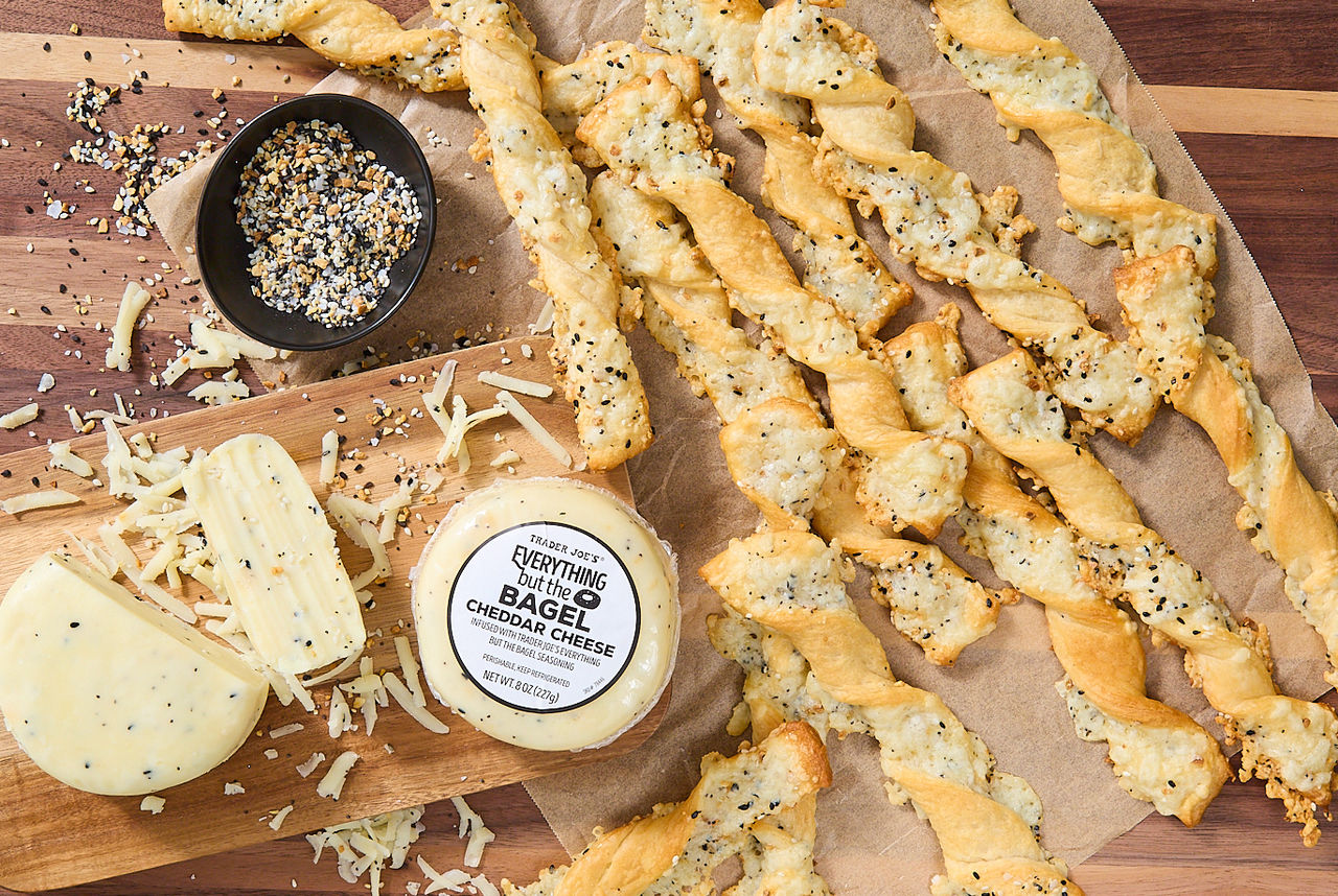 Trader Joe's Everything but the Bagel Cheddar Cheese; shown in recipe for EBTB Cheddar Cheese Twists; twists on parchment paper next to bowl of Everthing but the Bagel Seasoning blend