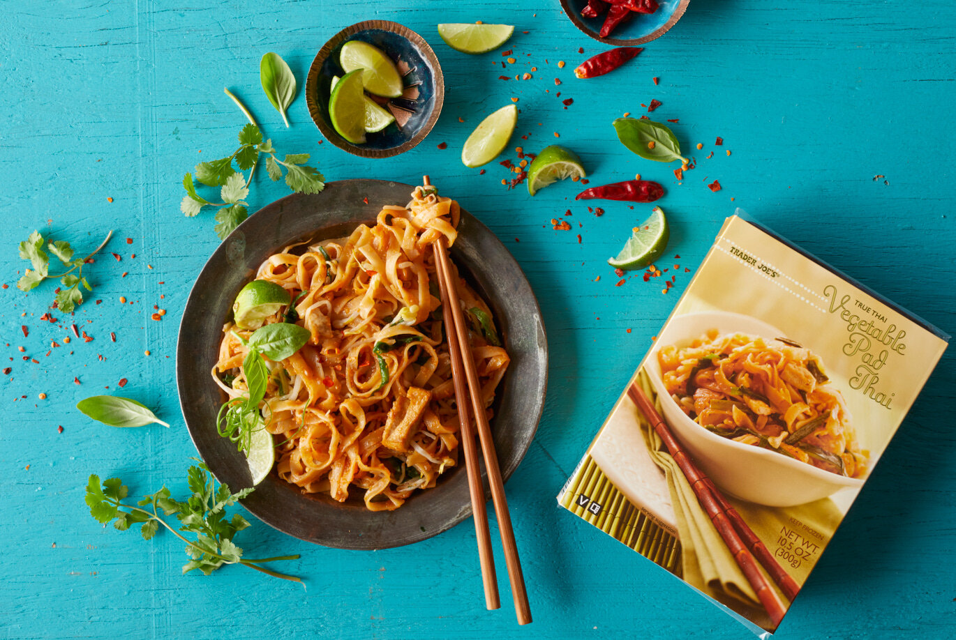 Trader Joe's Vegetable Pad Thai prepared and served on a plate with fresh lime wedges, basil and cilantro