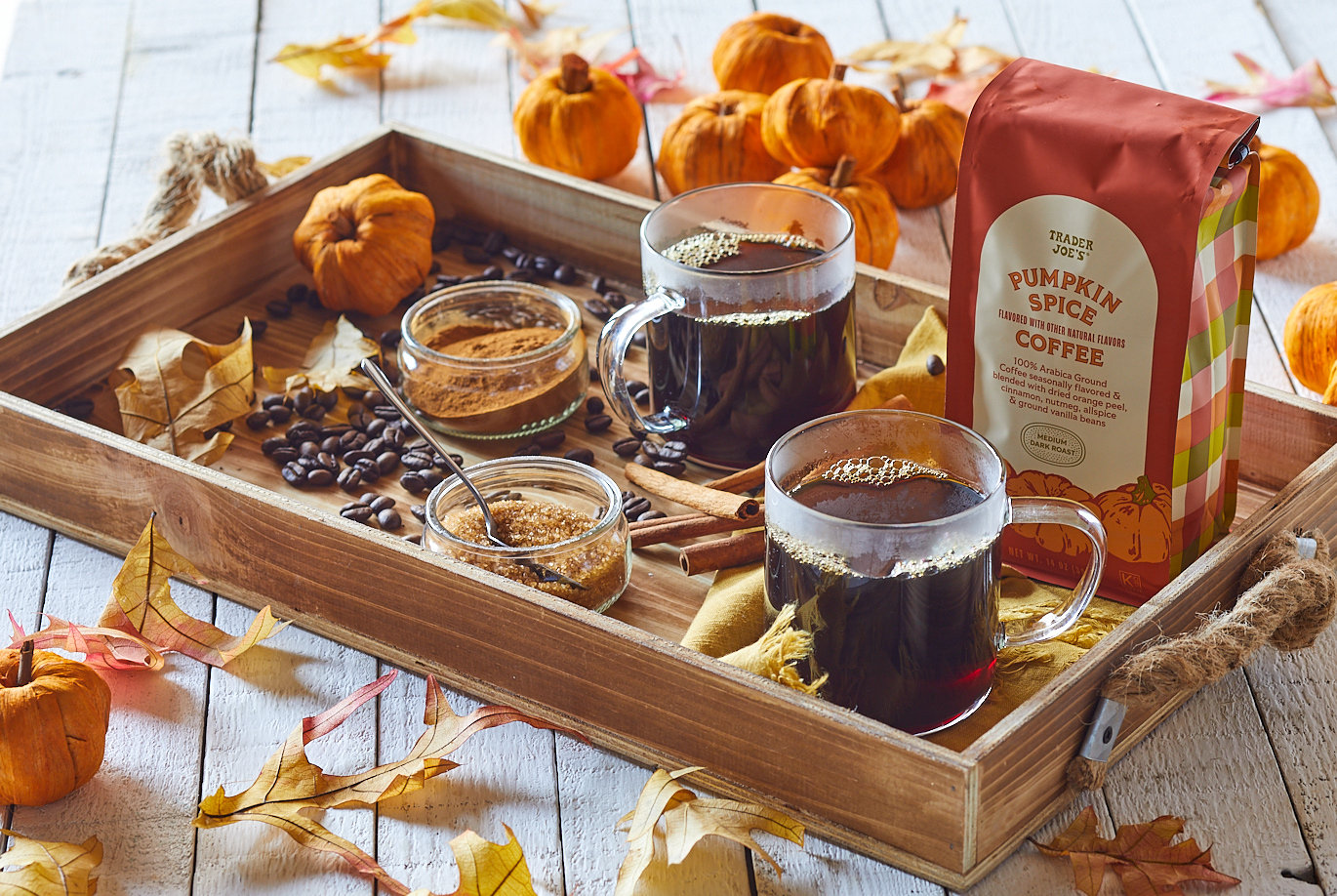 Trader Joe's Pumpkin Spice Coffee package next to a cup of coffee and a slice of coffee cake